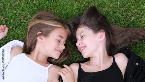 fraternal twins sisters. blonde and brunette teen girls in fashionable black and white clothes outdoors. sisterhood, siblings spending time together