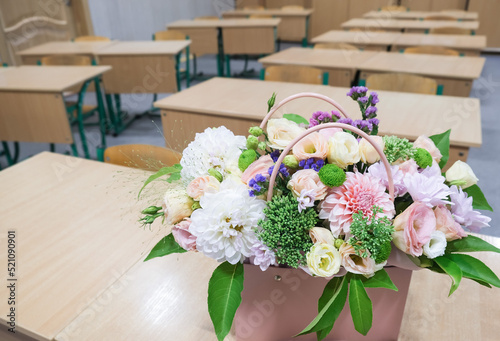 A bouquet of flowers stands on a table in the classroom. Greeting card with the beginning of the school year at school. photo