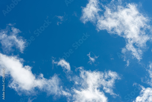 A clear blue sky with white clouds