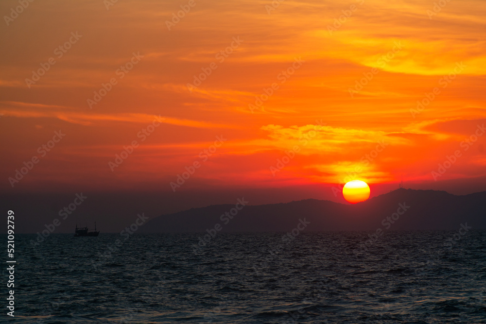 Sunset in the Gulf of Thailand. silhouette of the island and solar ball sets over the horizon.