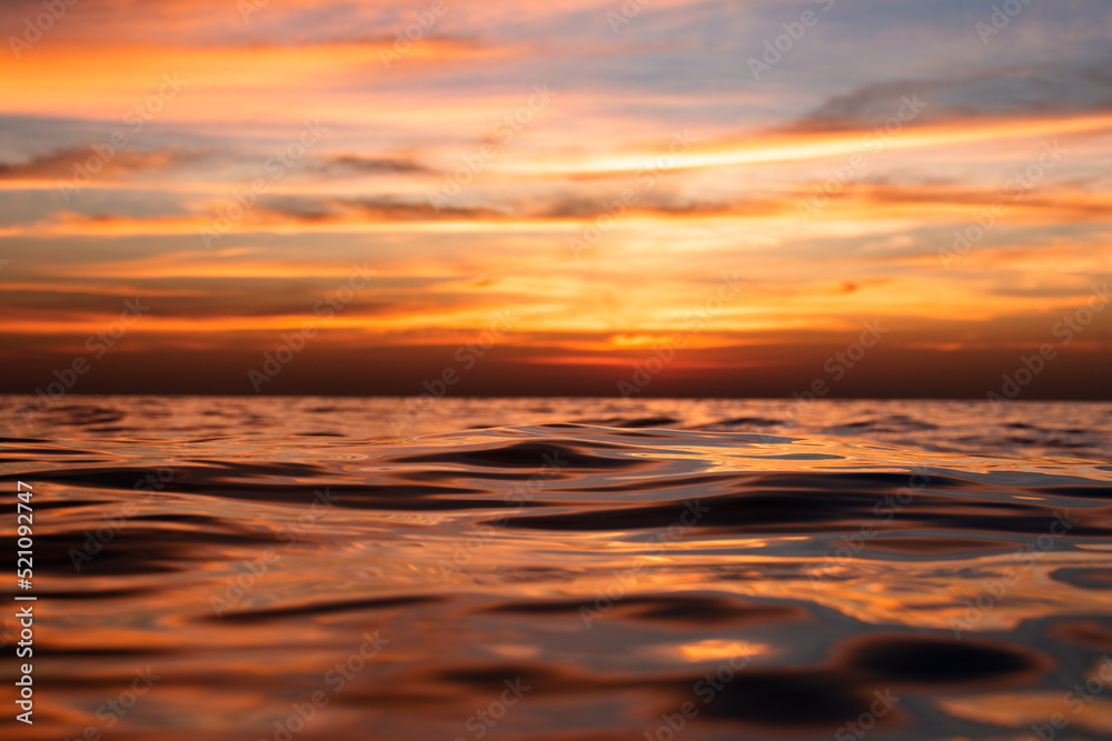 Fototapeta premium beautiful sea sunset, the wave closes the sun. View very close to the water
