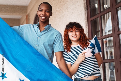 Multiracial friends couples together celebrating independence holding honduras flags.