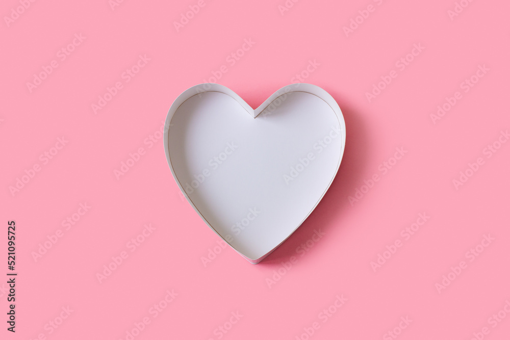 Cardboard box without a lid in the shape of a heart top view on a pink background. Place for invitation or text