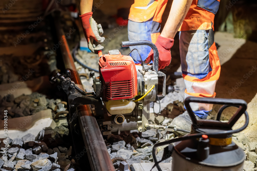 Mit einer Schienenbohrmachine wird in der Nacht eine Schiene gebohrt