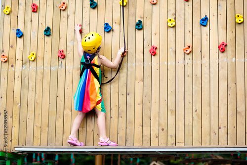 Photography Child in adventure park. Kids climbing rope trail.