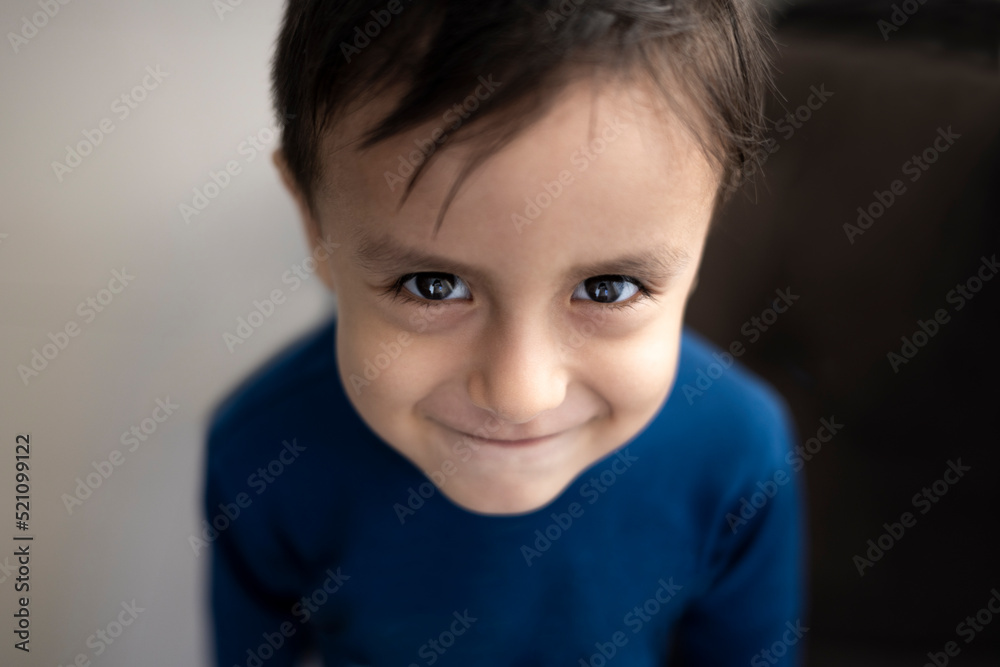 Portrait of a cute little latin boy. smart little child with charming smile having fun at home. Close-up shot.
