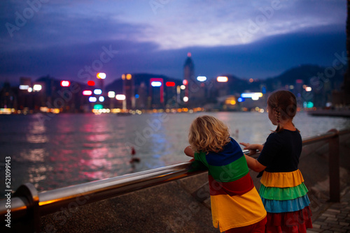 Photography Kids watch Hong Kong harbor skyline.