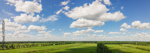 Blue sky panorama with clouds over tops of green trees. Blue sky and white cloud soft. White clouds background.