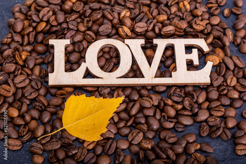 Close-up of coffee beans in the shape of a heart and the inscription love