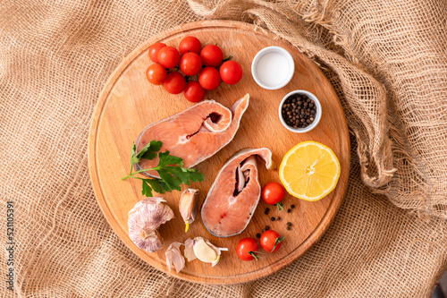  Raw red fish steaks on a wooden cutting board, ingredients for cooking. High quality photo