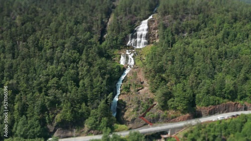 Aerial view of the Svandalsfossen waterfall. Rusty metal walkways and stairs on the mountainside. Tilt-shift. photo
