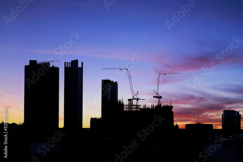 Silhouette construction with sunset sky background.