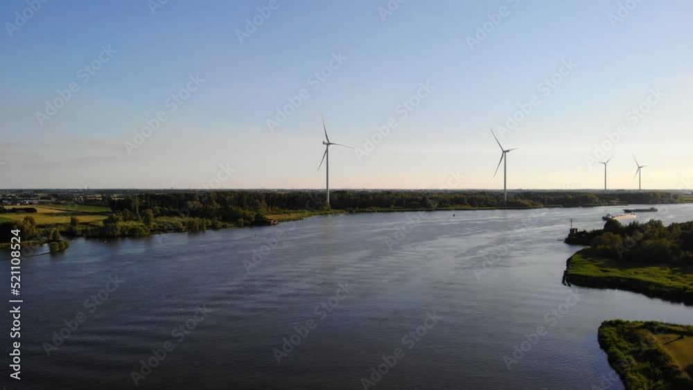 Aerial Dolly Forward Over Oude Maas With Still Wind Turbines And Silhouette Of Ship Approaching In Distance Aerial Dolly Forward Over Oude Maas With Still Wind Turbines And Silhouette Of Ship Approaching In Distance