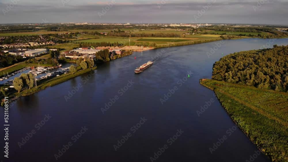 Aerial View Of FPS Waal Cargo Container Vessel Approaching River Bend On Oude Maas. High Angle Shot Aerial View Of FPS Waal Cargo Container Vessel Approaching River Bend On Oude Maas. High Angle Shot