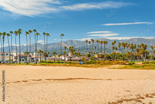 Fotografie Wide sandy Santa Barbara beach with beautiful palm trees, city architecture in s
