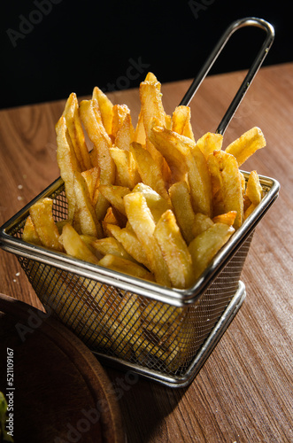 the photograph shows some french fries on a metal rack