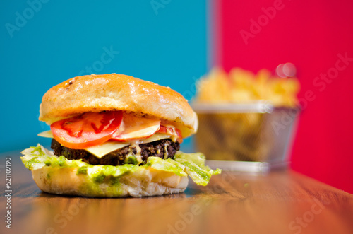 the photograph shows a delicious hamburger accompanied by french fries