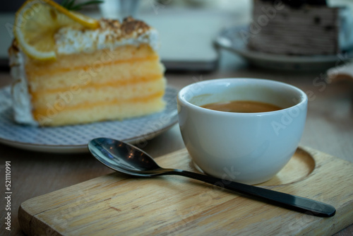 Hot coffee with orange cake on wood table