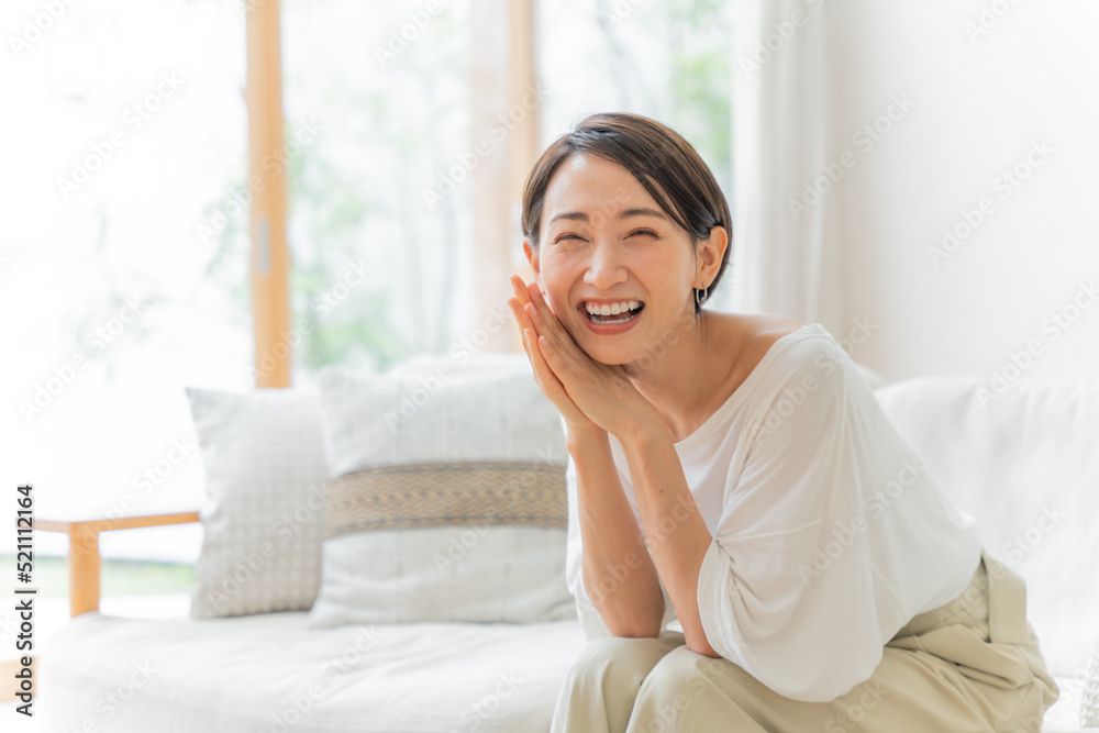 リビングでリラックスする笑顔のミドル女性 リビングでリラックスする笑顔のミドル女性