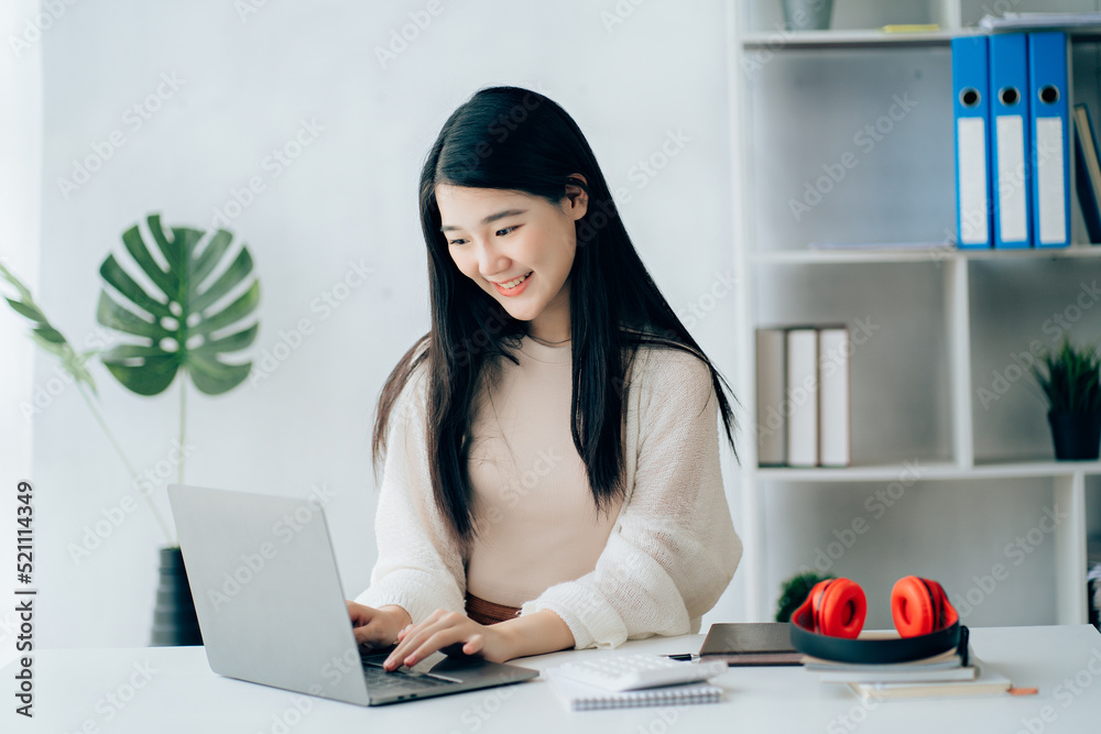 Happy young Asian student woman wearing headphones looking at webcam, looking at camera, during virtual meeting or video call talk Happy young Asian student woman wearing headphones looking at webcam, looking at camera, during virtual meeting or video call talk