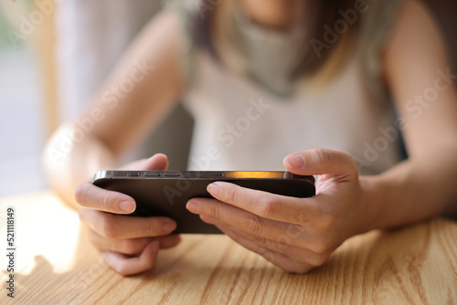 Woman hand using a smartphone for Stock exchange trading online in the coffee shop, business concept