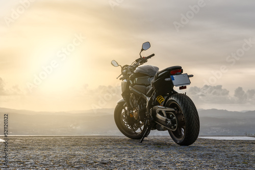 Obraz na plátně Motorcycle parked in front of the sunset