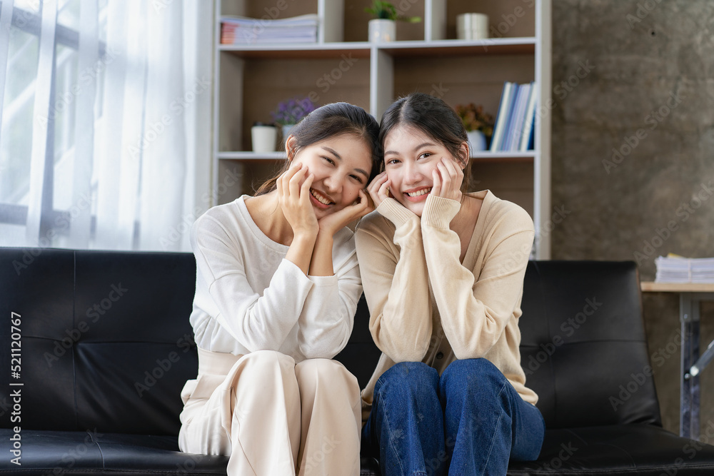 Concept of LGBT, homosexuality, portrait of two Asian women posing happily together and loving each other while playing together on the sofa. Concept of LGBT, homosexuality, portrait of two Asian women posing happily together and loving each other while playing together on the sofa.