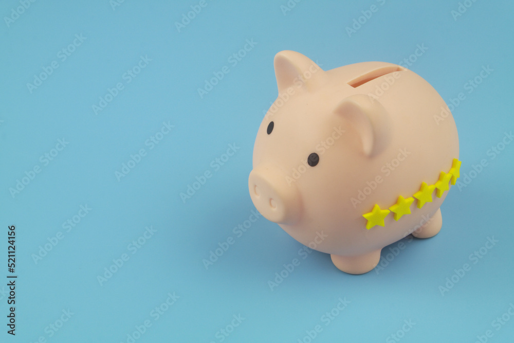 Financial fund with good reputation and rating concept. Piggy bank with 5 yellow stars on blue background. Copy space for text.