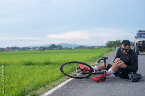 bike injury Male cyclist falls on a road bike while riding a bicycle. Bicycle accident, knee injury Sport outside concept.