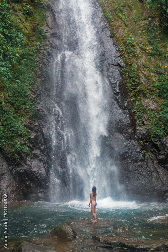 woman in front of a waterfall in the middle of the cloud forest