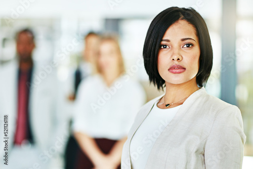 Fotografia, Obraz Serious, focused and confident female lawyer looking at the camera and standing in her office with her team