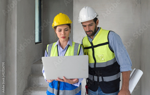 Fotografie Young engineer with laptop computer explain to foreman about a floor plan
