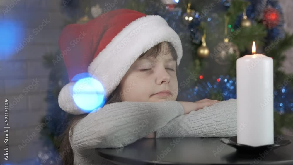 Little girl miracle at Christmas candle at home. A little Santa child wait for miracle by the New year candle in the room. Little girl miracle at Christmas candle at home. A little Santa child wait for miracle by the New year candle in the room.
