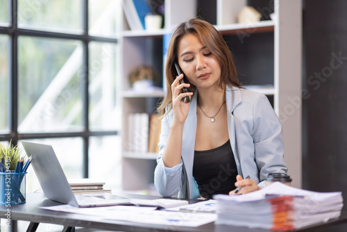 Busy business accountant Asian woman making call phone in home office and business working, Startup, report, tax, accounting, statistics, and analytic research concept