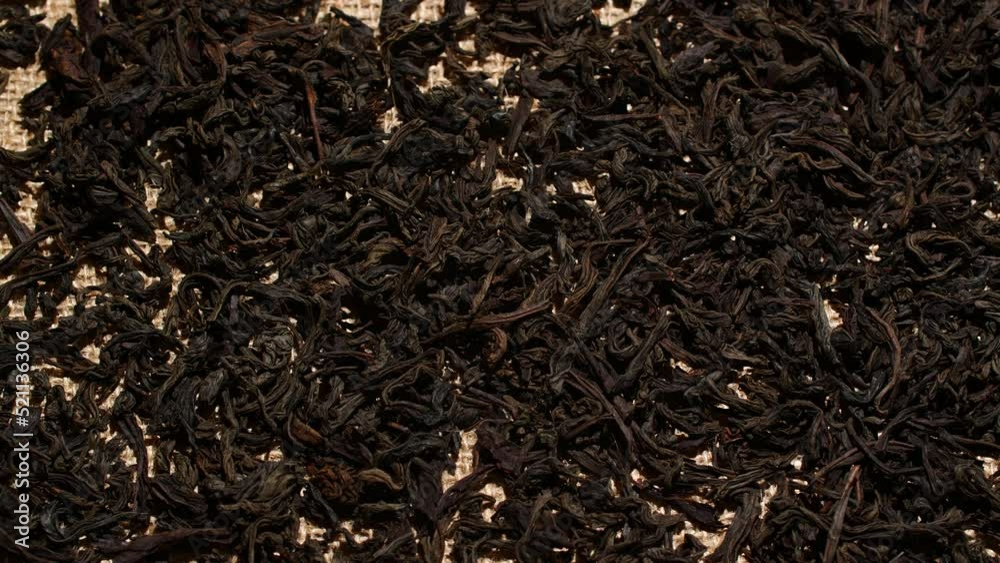 Close-up herbal black or green tea leaves texture on jute sack, food background Close-up herbal black or green tea leaves texture on jute sack, food background