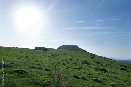 green meadow on the peak of mount beriain, with the hermitage of san donato on the summit. Sierra de Andia, Navarre, Spain