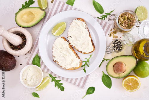 Avocado and cream cheese toasts preparation - grilled or toasted bread with cheese smeared 
