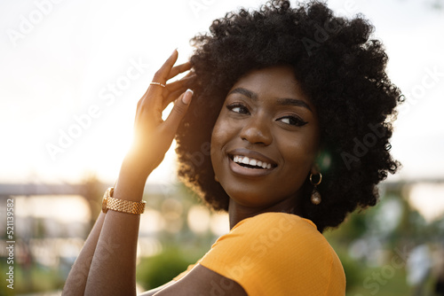 Fotografie Portrait of a young african american woman smiling standing at the city
