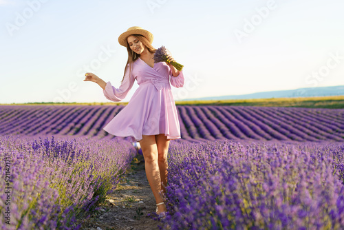 Young woman in a lilac dress walking in a lavender field