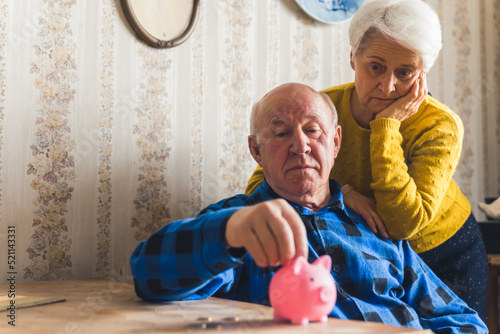 Quadro su tela Sad, lost and worried caucasian senior couple counting coins taken out from a piggy bank while sitting by the table