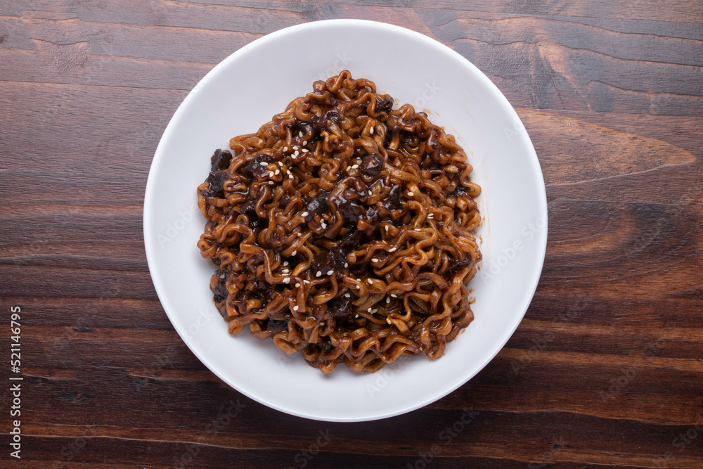 Jajangmyeon or JJajangmyeon instant noodles black bean sauce Korean food style in a white cup. Jajangmyeon or JJajangmyeon instant noodles black bean sauce Korean food style in a white cup.