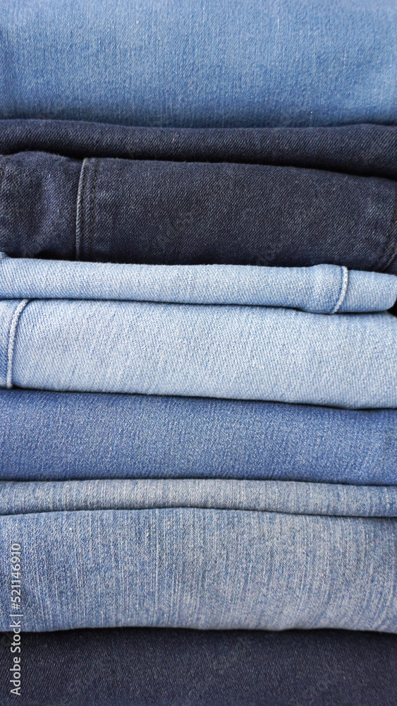 Stack of various shades of neatly folded vintage denim jeans