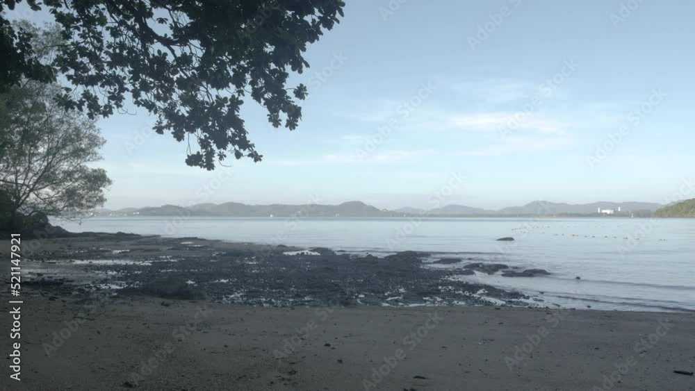 the reef beach with gray sand and reef rocky and wave from peaceful sea in sunshine daytime the reef beach with gray sand and reef rocky and wave from peaceful sea in sunshine daytime
