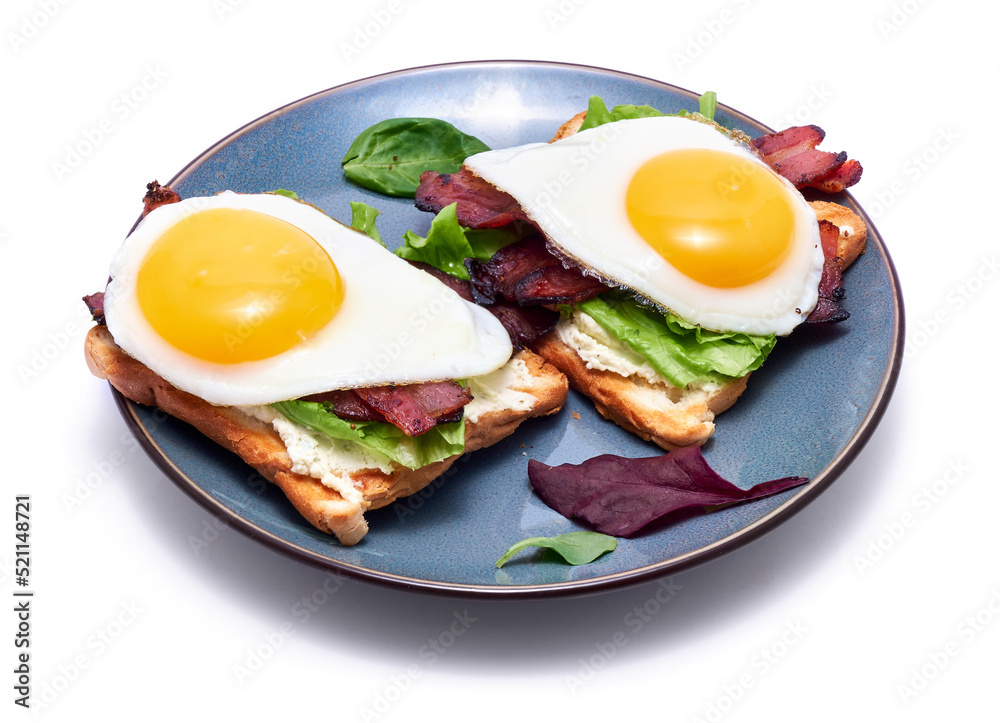 Fried eggs, bacon and cream cheese sandwiches on a plate on wooden table at domestic kitchen Fried eggs, bacon and cream cheese sandwiches on a plate on wooden table at domestic kitchen