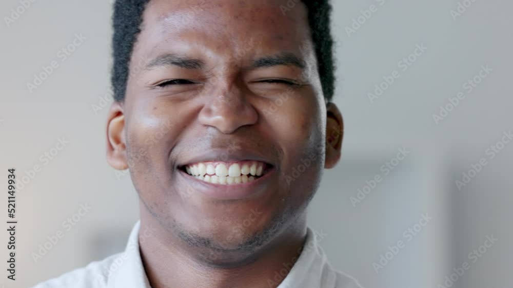Closeup of a happy business man laughing at a funny joke, being carefree and having fun at work alone. Portrait of the face of a young, smiling and positive professional being silly and goofy Closeup of a happy business man laughing at a funny joke, being carefree and having fun at work alone. Portrait of the face of a young, smiling and positive professional being silly and goofy