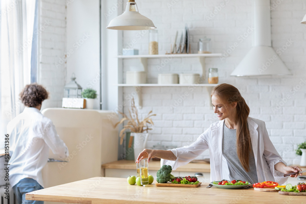 Happy couple is preparing healthy food on light kitchen. Cooking together salad Happy couple is preparing healthy food on light kitchen. Cooking together salad