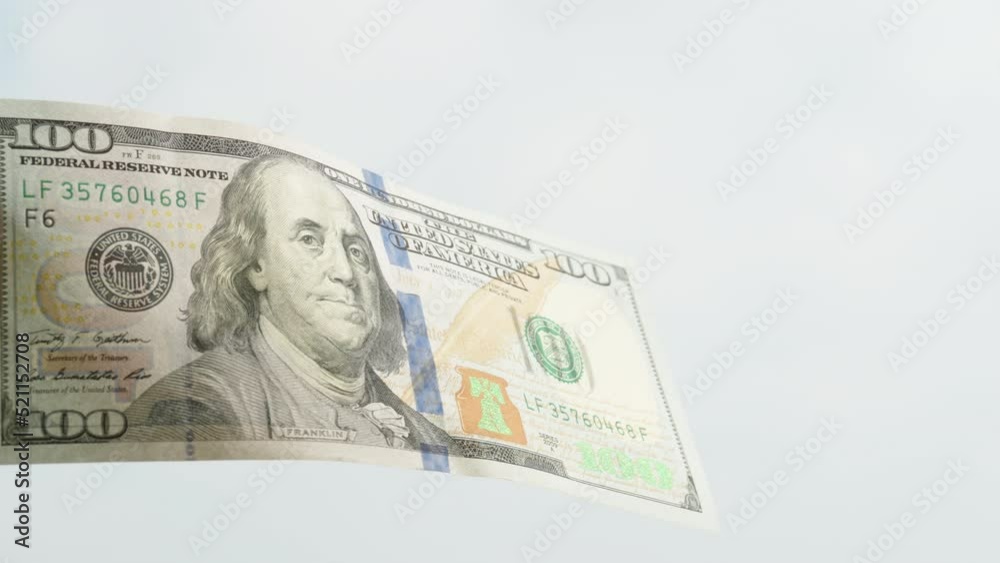 A hundred-dollar bills ways in the wind against the sky, close-up. A hundred-dollar bills ways in the wind against the sky, close-up.