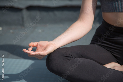 Close up view of a woman doing the lotus position of yoga