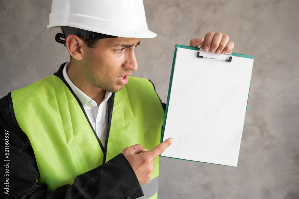 Arab architect pointing finger at clipboard with blank space, building Arab architect pointing finger at clipboard with blank space, building