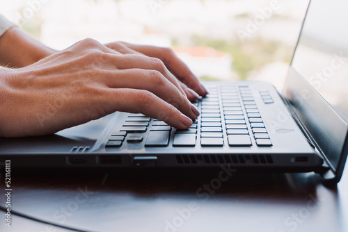 Obraz na płótnie A woman working on a laptop, closeup of her hands and keyboard, the blank screen in the form of a clean template, businesswomen in the office on a light background. w salonie